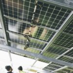 Close-up of solar panels being installed outdoors with technicians visible.